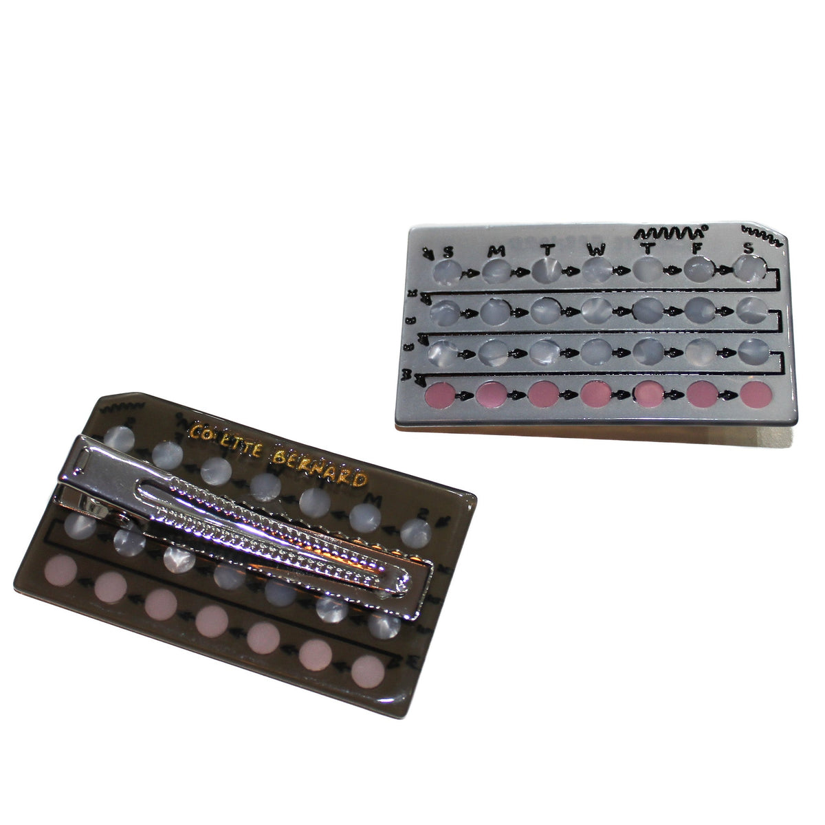 A rectangle hair clip designed to look like pill birth control. The clip is an alligator style clip. Two clips on a white background, one showing the back of the clip