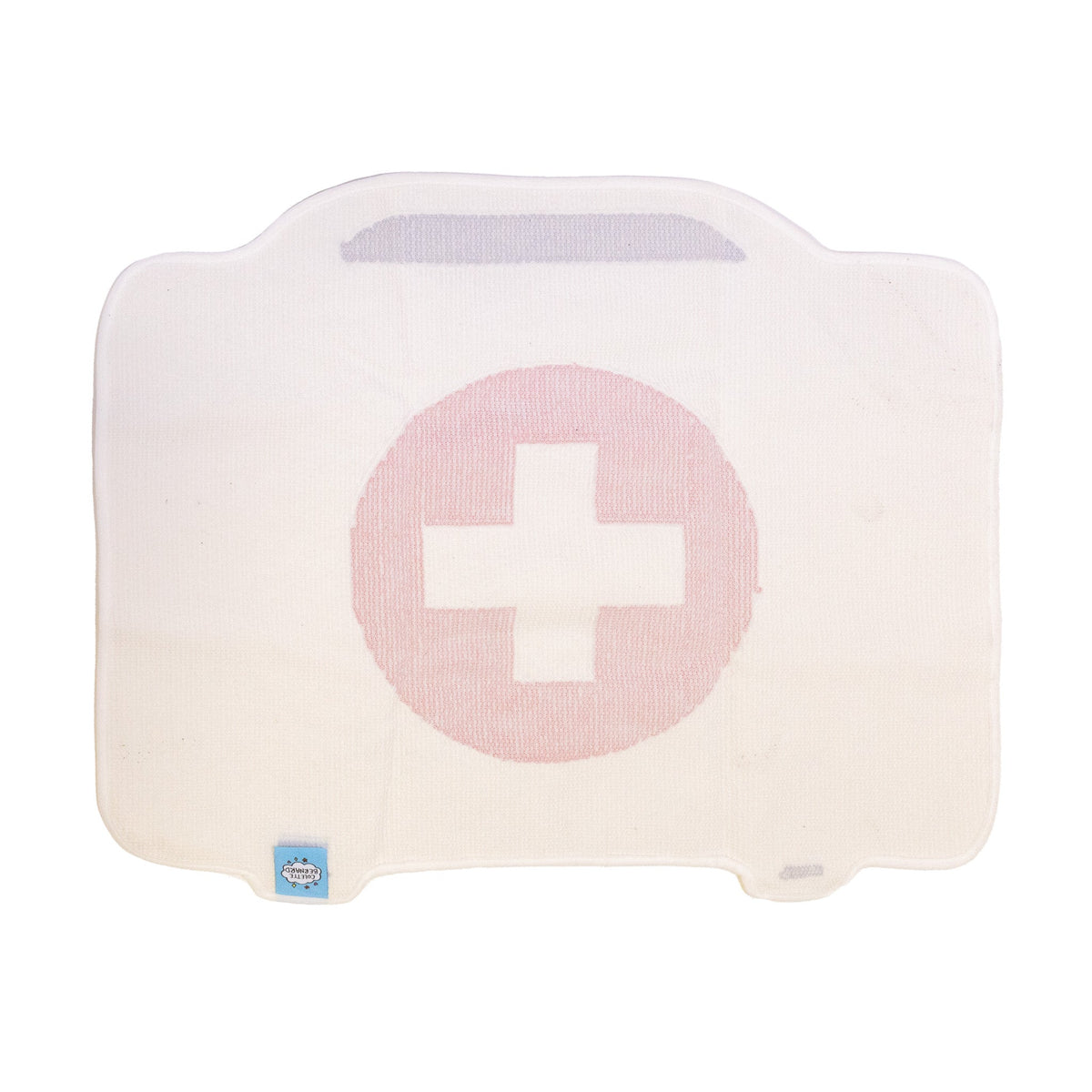 The back of the First Aid Kit Rug, showing the cream backing with the faint outline of the red cross design and the small blue logo tag in the corner.