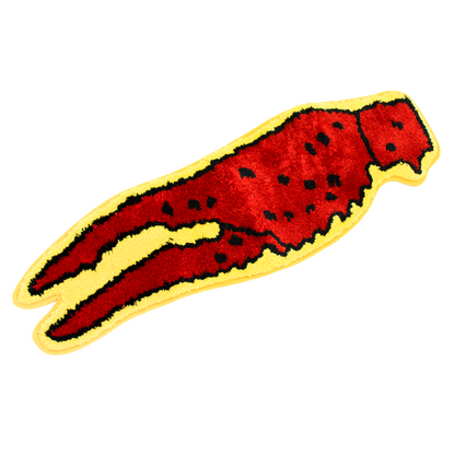 Decorative rug shaped like a red crawfish claw with black spots and a yellow border, on a white background.