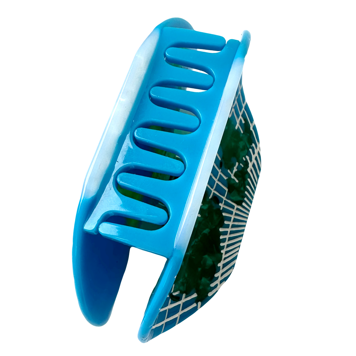 The World Map Hair Claw from the side, showing the blue teeth of the claw and the green and white grid map pattern on the outer face.