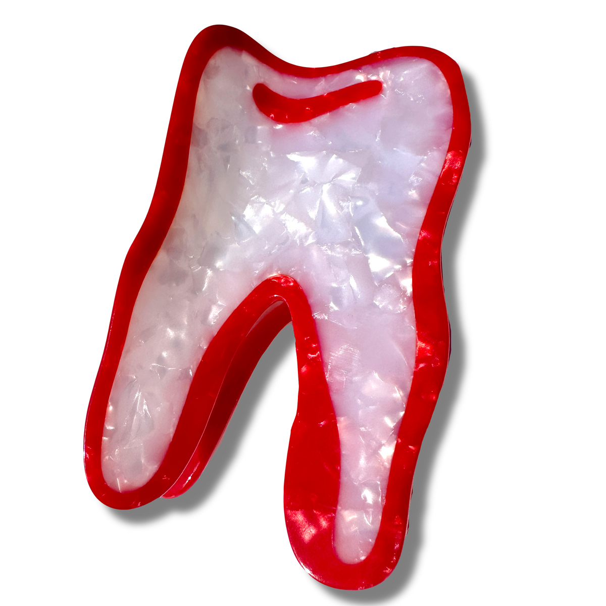 A hair claw shaped like a wisdom tooth. it is white with a thick red border