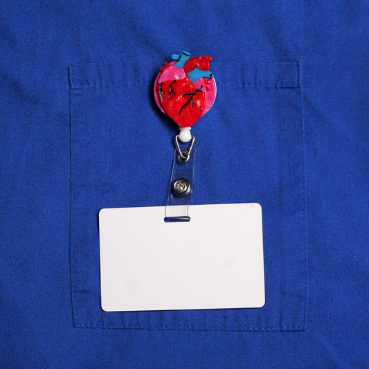 Red anatomical heart badge reel with a white card on a blue shirt