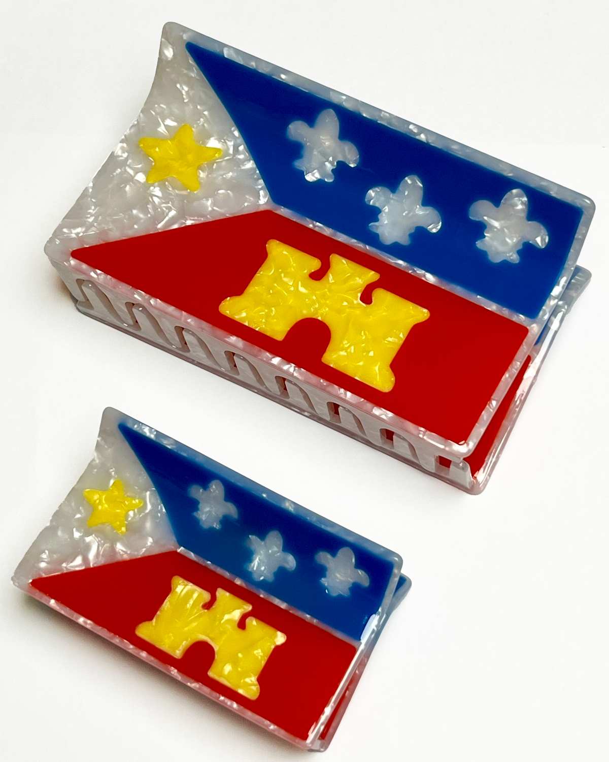 An acadiana flag mega claw and an acadiana flag hair claw sitting near each other on a white background