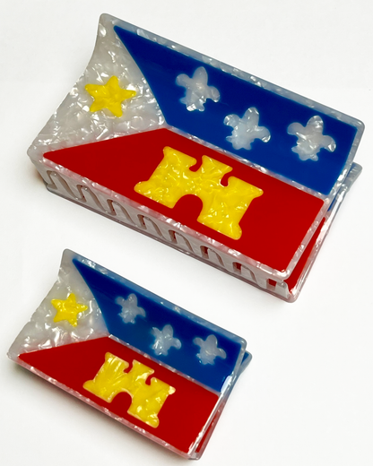 An acadiana flag mega claw and an acadiana flag hair claw sitting near each other on a white background