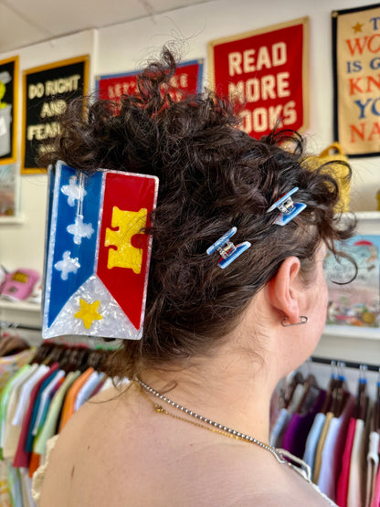 An acadiana flag mega claw in a persons hair.
