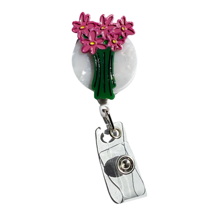 Retractable badge holder with pink flowers on a white background