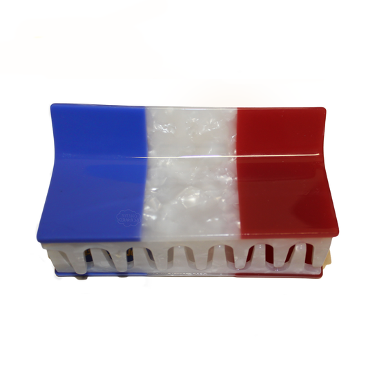 The French Flag Claw, a rectangular hair claw with blue, white pearl and red vertical stripes like the French flag, shown closed on a white background.