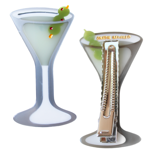 Two Martini Glass Hair Clips, one showing the front martini glass with a pale green drink and two olives on a pick, the other flipped to show the silver alligator clip and gold Colette Bernard logo, on a white background.