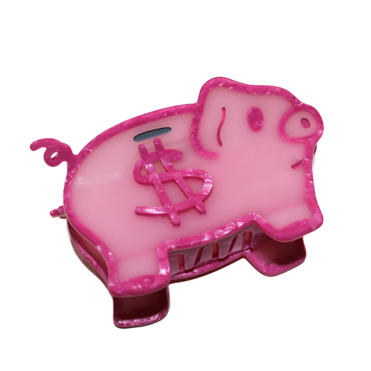 The Piggybank Claw, shaped like a pale pink pig with a hot pink marbled outline, a curly tail, a coin slot and a dollar sign on its side, on a white background.