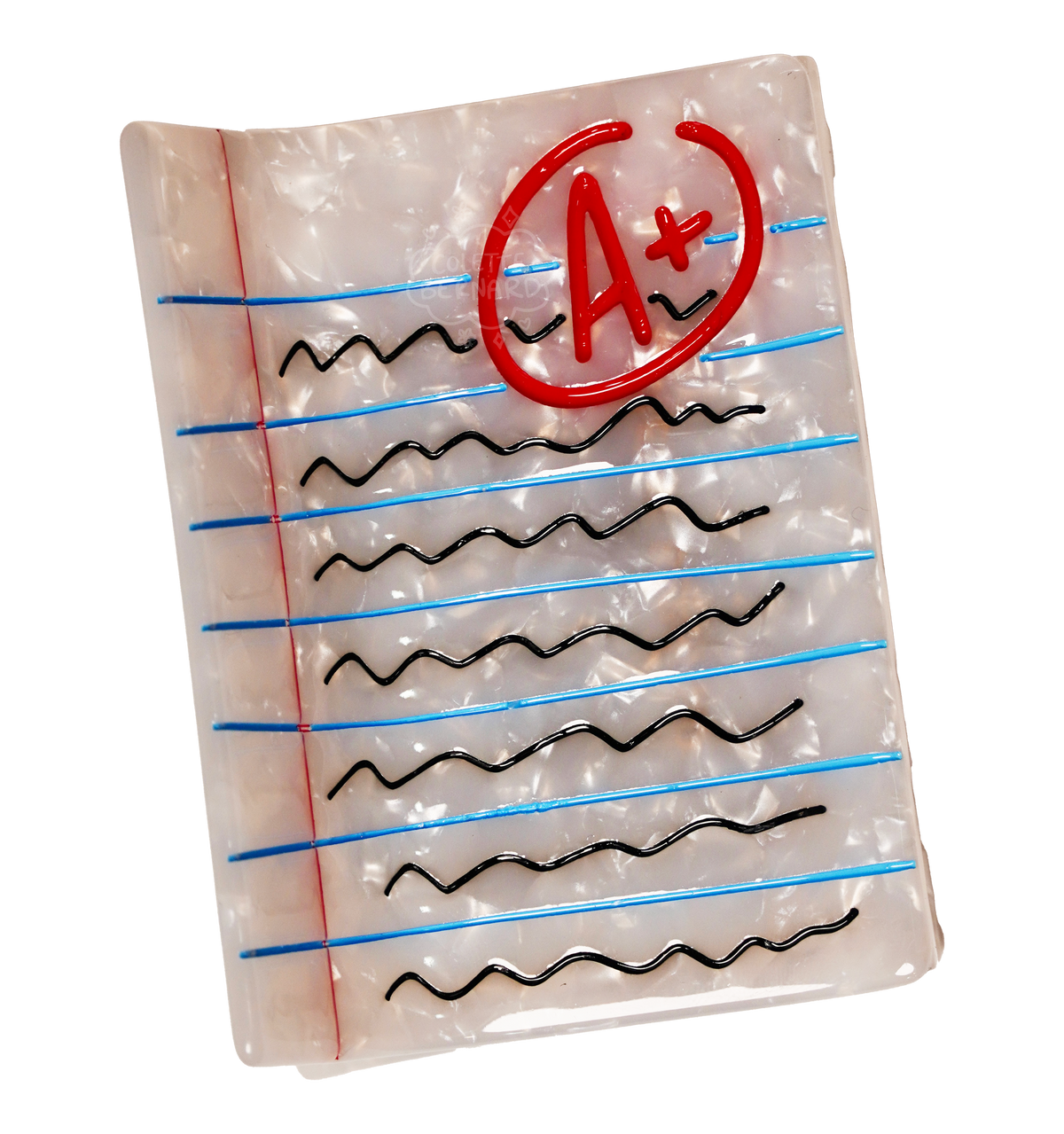 A hair claw designed to look like a loose leaf sheet of lined paper with black scribbles representing writing. There is an A+ circled in red.