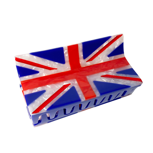 The United Kingdom Flag Claw, a rectangular hair claw designed like the Union Jack in blue, red and white pearl, shown at an angle so the teeth are visible, on a white background.
